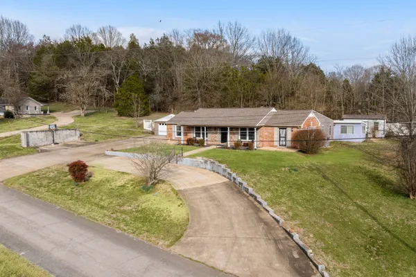 a view of a lake with a yard and large trees