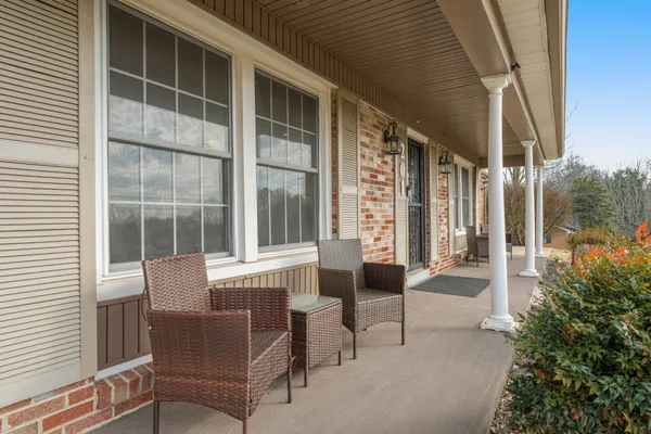 a balcony with furniture and next to a window