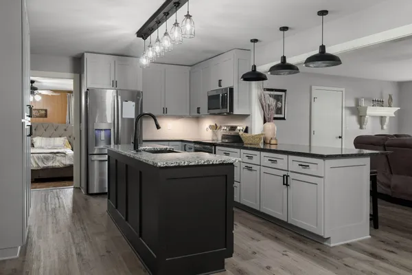 a kitchen with stainless steel appliances granite countertop a sink a stove a refrigerator and cabinets