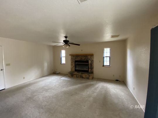 717 North Inyo Street Ridgecrest, CA 93555 - Photo 5 of 26 an empty room with a fireplace and windows