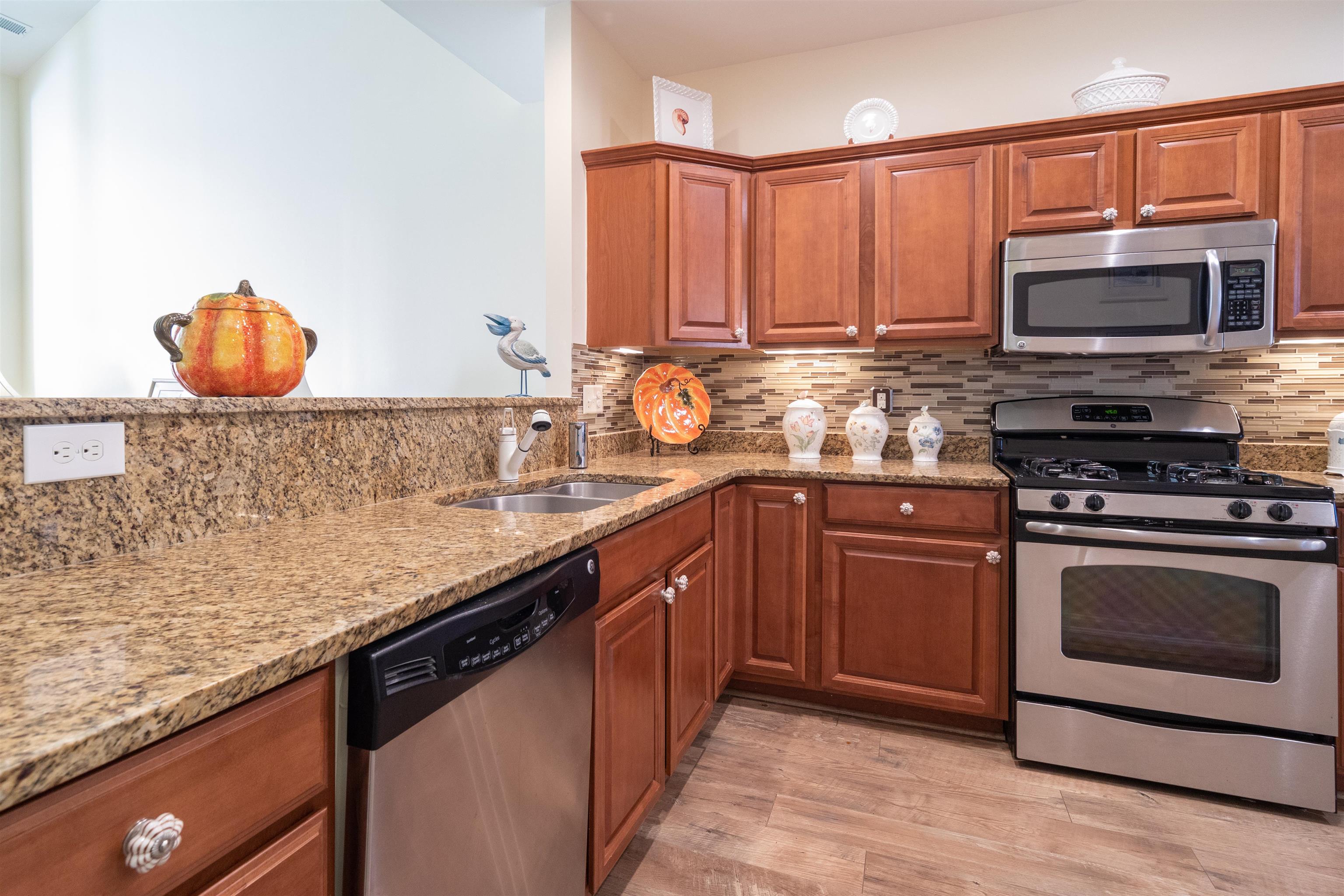 206 Seacrest Lane, Unit 155 Rio Grande, NJ 08242 - Photo 10 of 50 a kitchen with stainless steel appliances granite countertop a stove a sink and a microwave