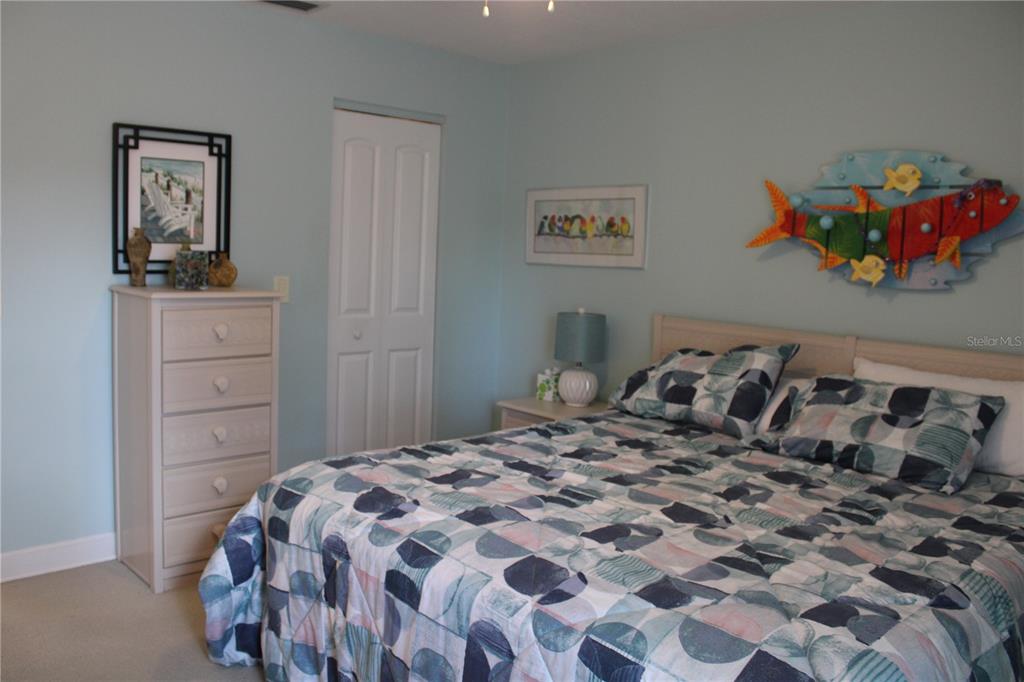335 Windrush Loop, Unit 335 Tarpon Springs, FL 34689 - Photo 11 of 18 a bedroom with a bed and painting on the wall