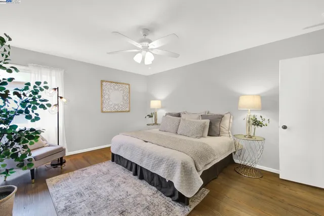 a bedroom with a bed painting on wall and a potted plant