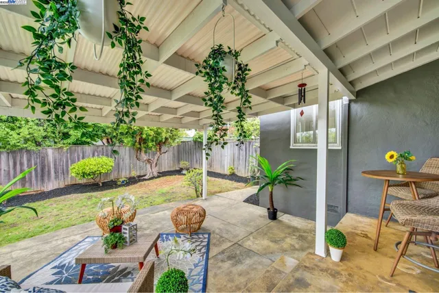 a view of a backyard with table and chairs potted plants
