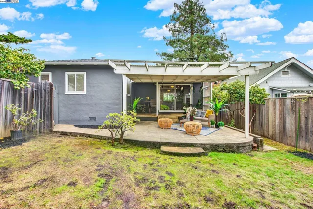 a view of a house with backyard and sitting area