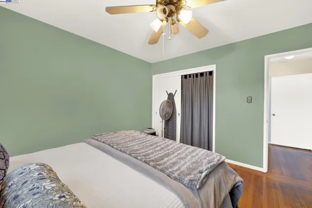 a bedroom with a bed and wooden floor