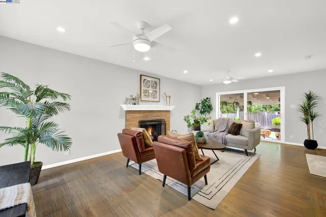 a living room with furniture a fireplace and a potted plant