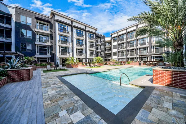 a kitchen with granite countertop a refrigerator stove and wooden cabinets