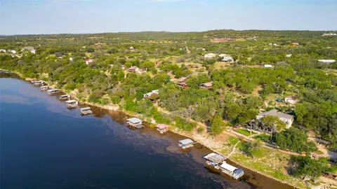 an aerial view of residential houses with outdoor space and trees all around