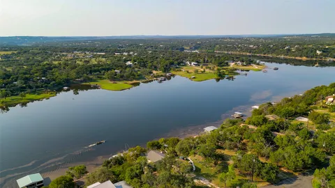 an aerial view of lake and residential houses with outdoor space
