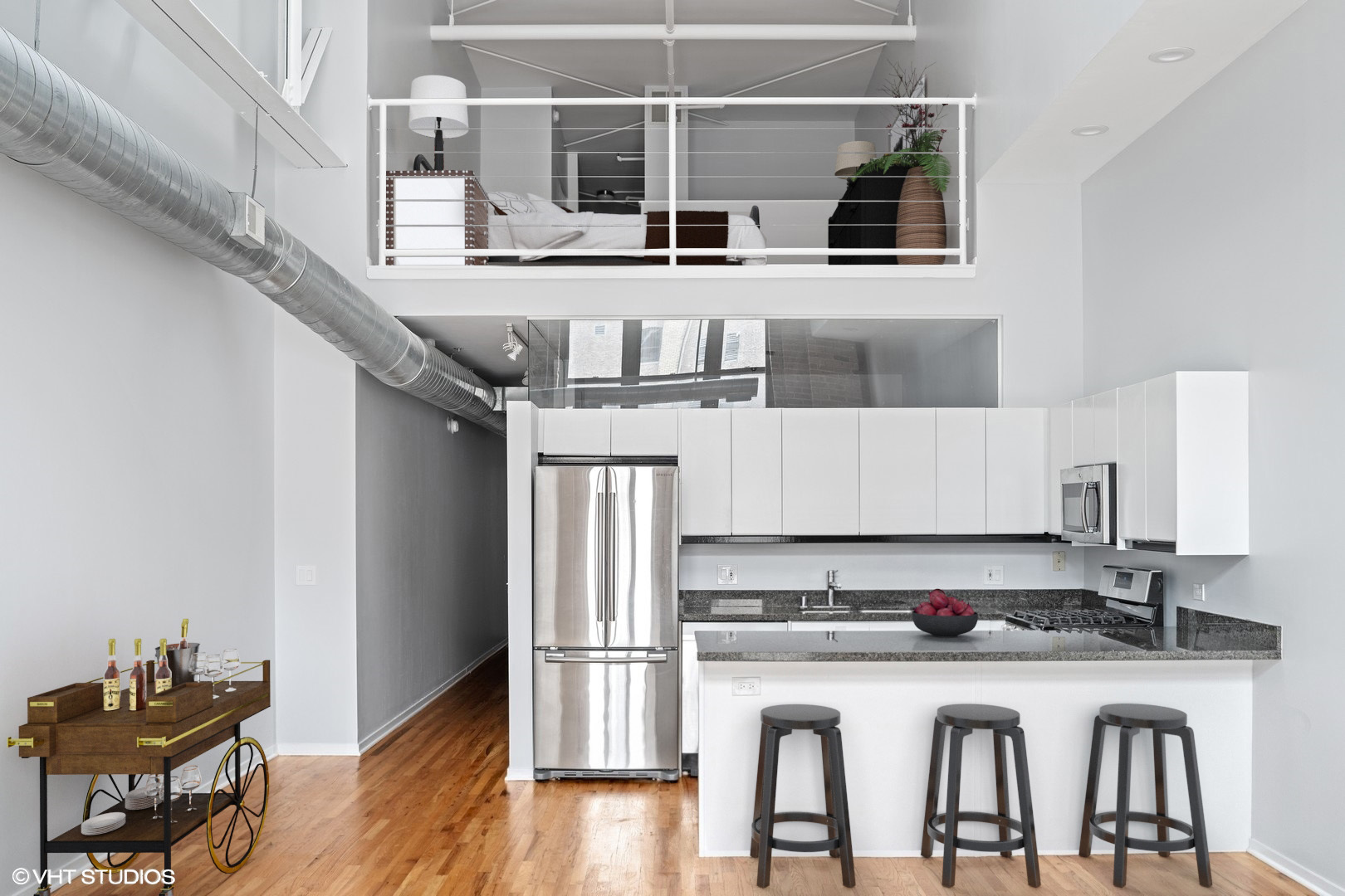 203 South Sangamon Street, Unit 304 Chicago, IL 60607 - Photo 2 of 15 a kitchen with stainless steel appliances kitchen island a table chairs in it and wooden floors