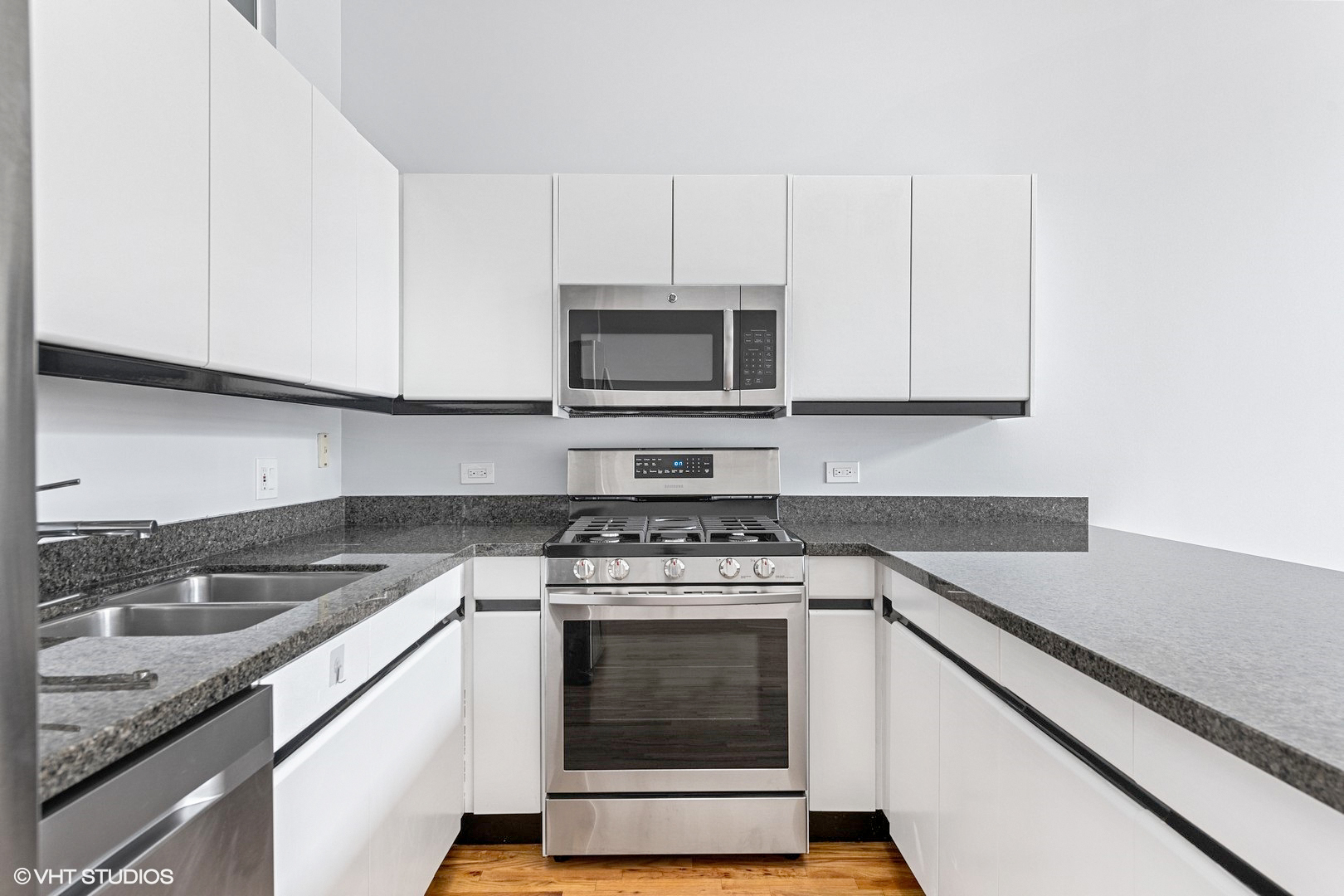203 South Sangamon Street, Unit 304 Chicago, IL 60607 - Photo 4 of 15 a kitchen with granite countertop white cabinets and stainless steel appliances