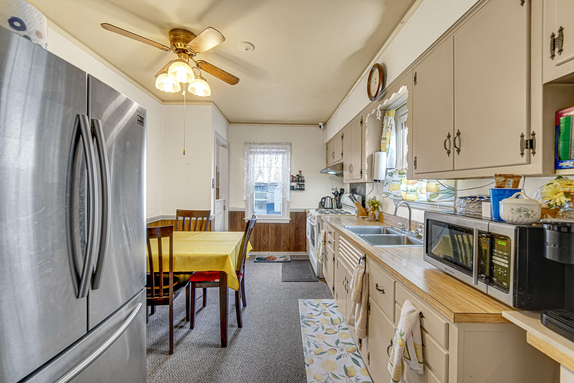 928 176th Street Hammond, IN 46324 - Photo 6 of 25 a kitchen with stainless steel appliances kitchen island granite countertop a refrigerator a stove a sink a dining table and chairs with wooden floor