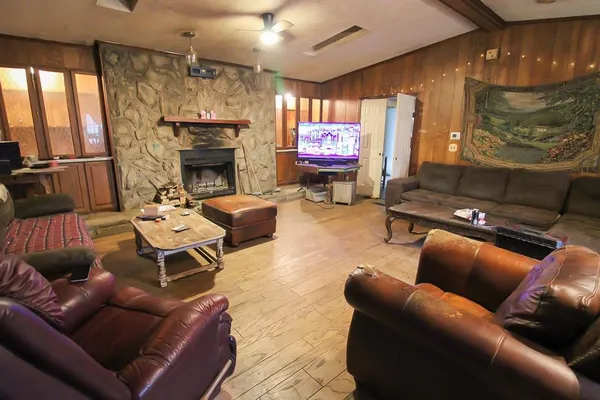 a outdoor living space with furniture a fireplace and a flat screen tv