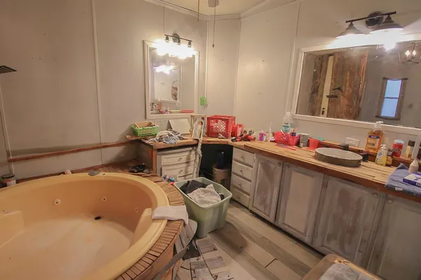 a bathroom with a tub sink and mirror