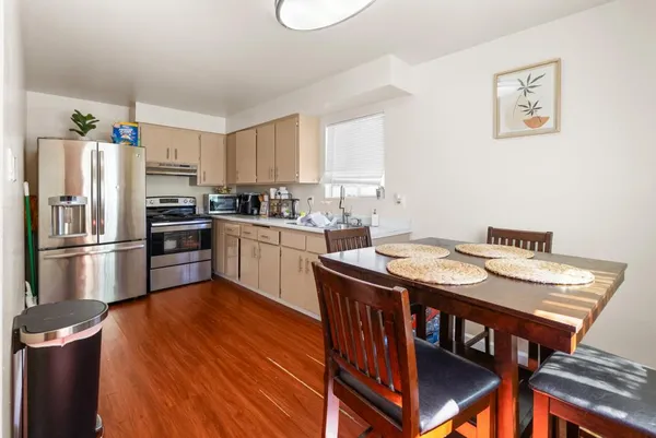 a view of a a dining room with furniture window and wooden floor