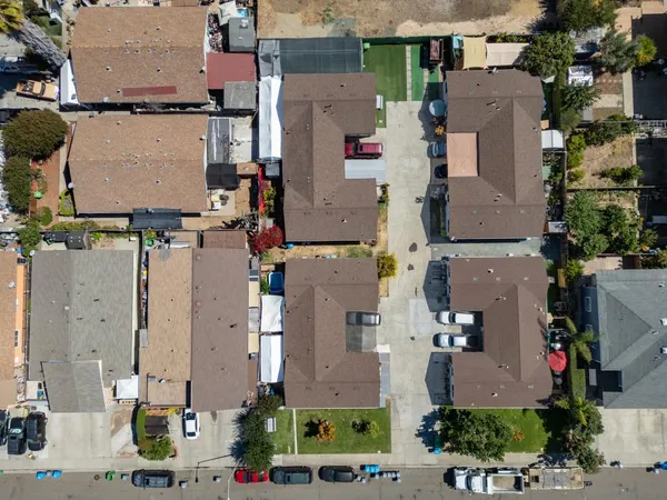 an aerial view of residential houses with outdoor space and parking