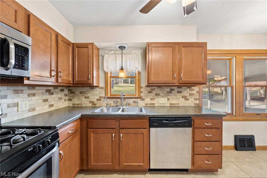 227 South Messner Road New Franklin, OH 44319 - Photo 22 of 44 Kitchen featuring hanging light fixtures, ceiling fan, sink, light tile floors, and stainless steel appliances