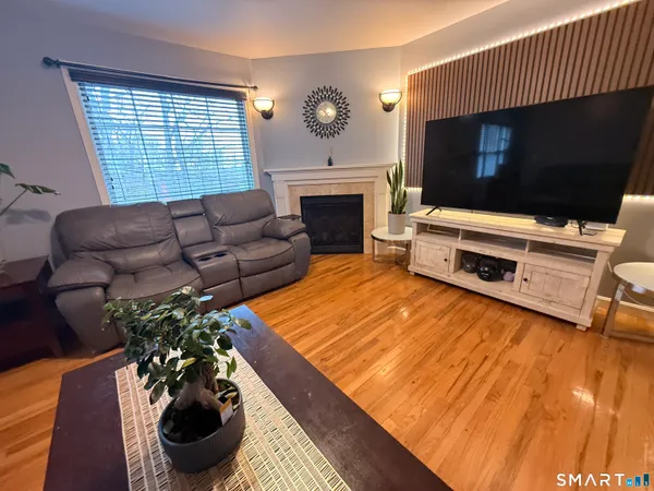 a living room with furniture a flat screen tv and a fireplace