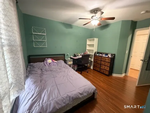 a bedroom with a bed and dresser with mirror