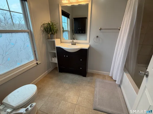 a bathroom with a sink a toilet and mirror