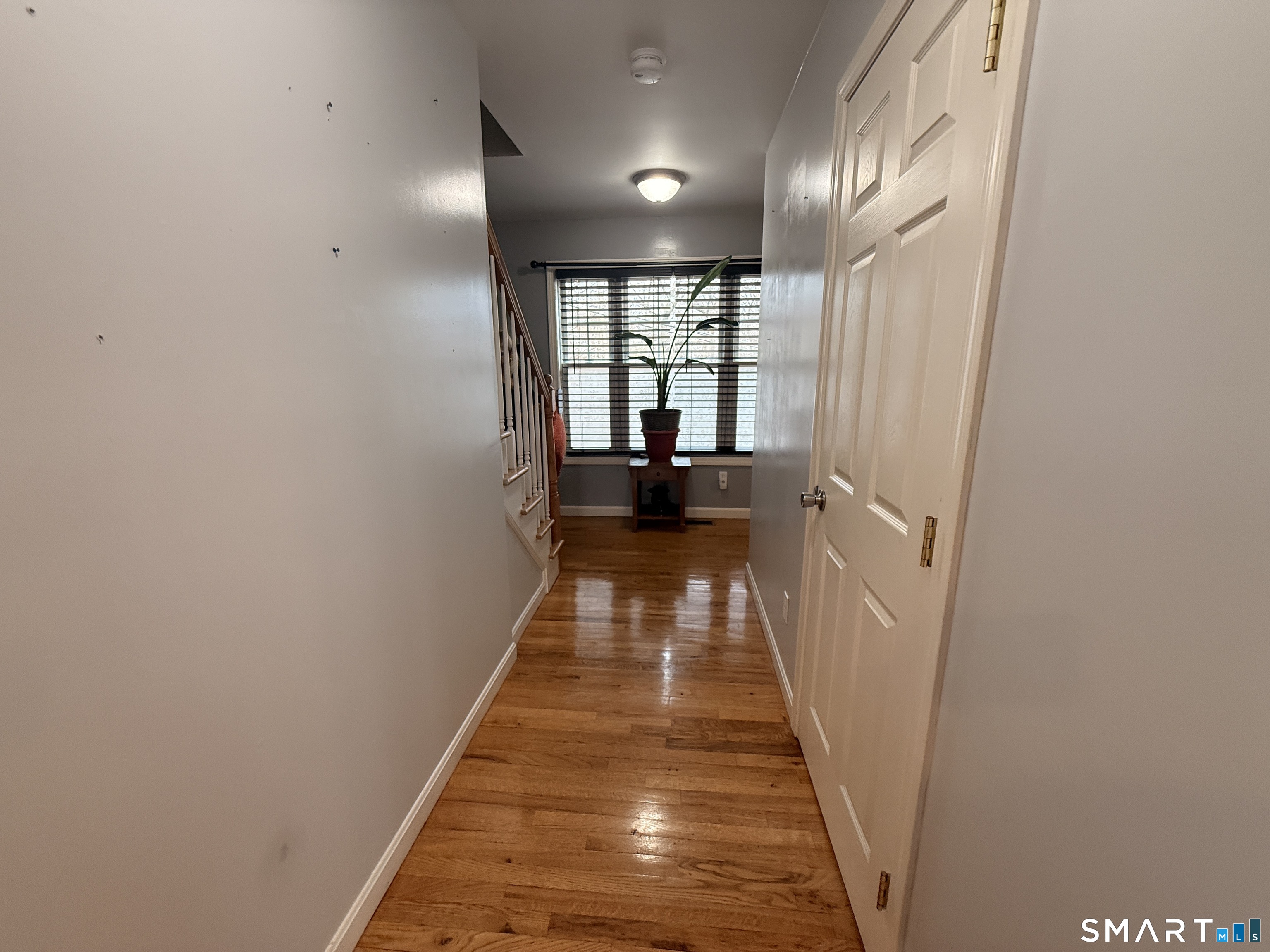 47 Oronoque Trail Shelton, CT 06484 - Photo 30 of 44 a view of a hallway with wooden floor and a bathroom