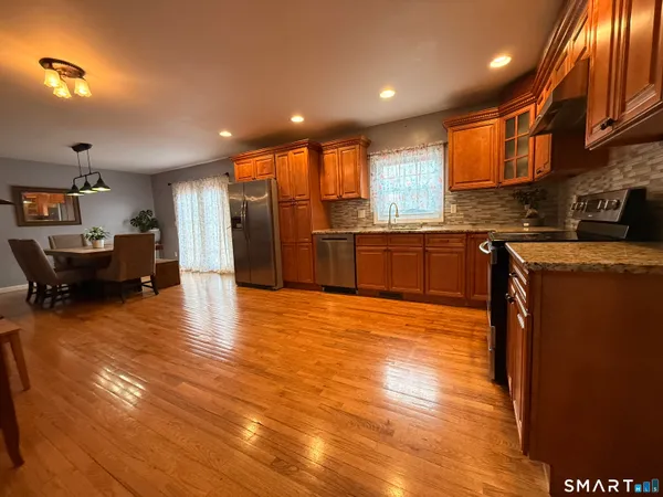 a dining room with furniture a chandelier and wooden floor