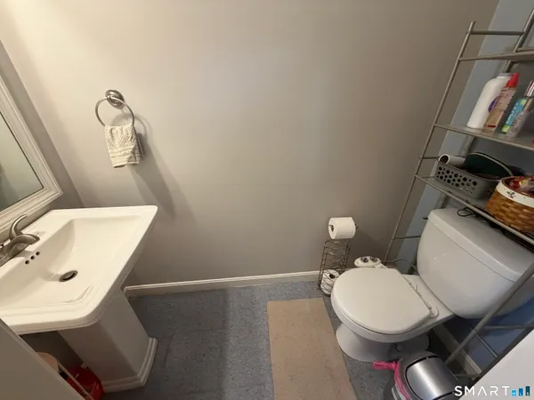 a bathroom with a toilet a sink and mirror