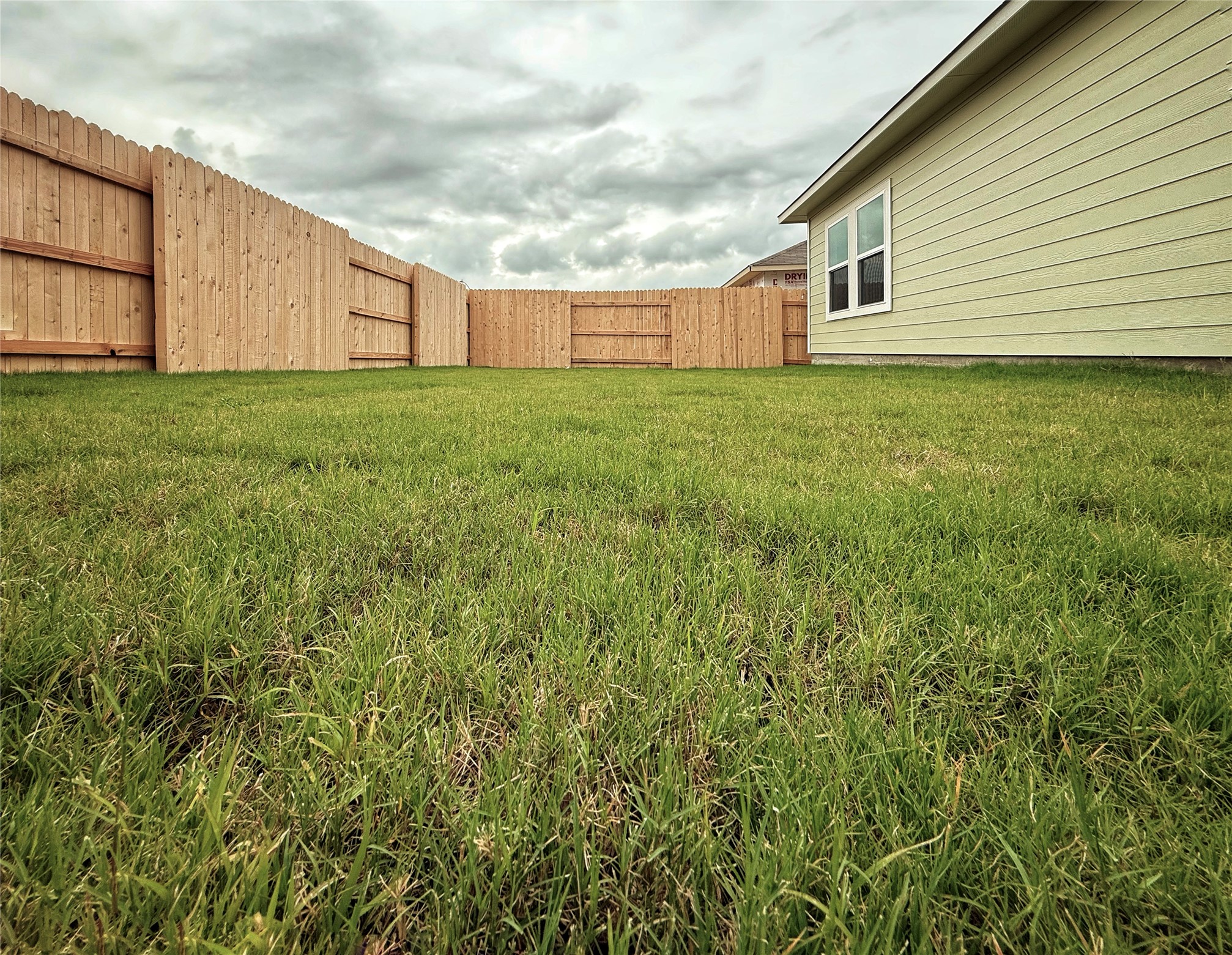 2714 Towy Road Manor, TX 78653 - Photo 17 of 22 Secure backyard space features fresh green lawn and privacy fencing, perfect for outdoor activities.