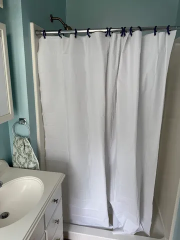 a bathroom with a shower curtain and a sink