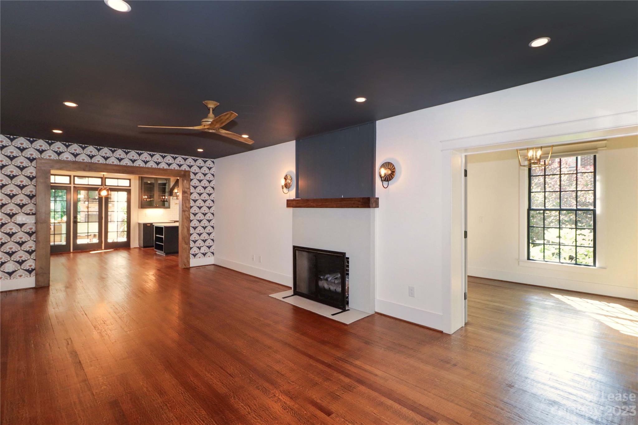 517 Lorimer Road Davidson, NC 28036 - Photo 12 of 48 an empty room with wooden floor fireplace and windows