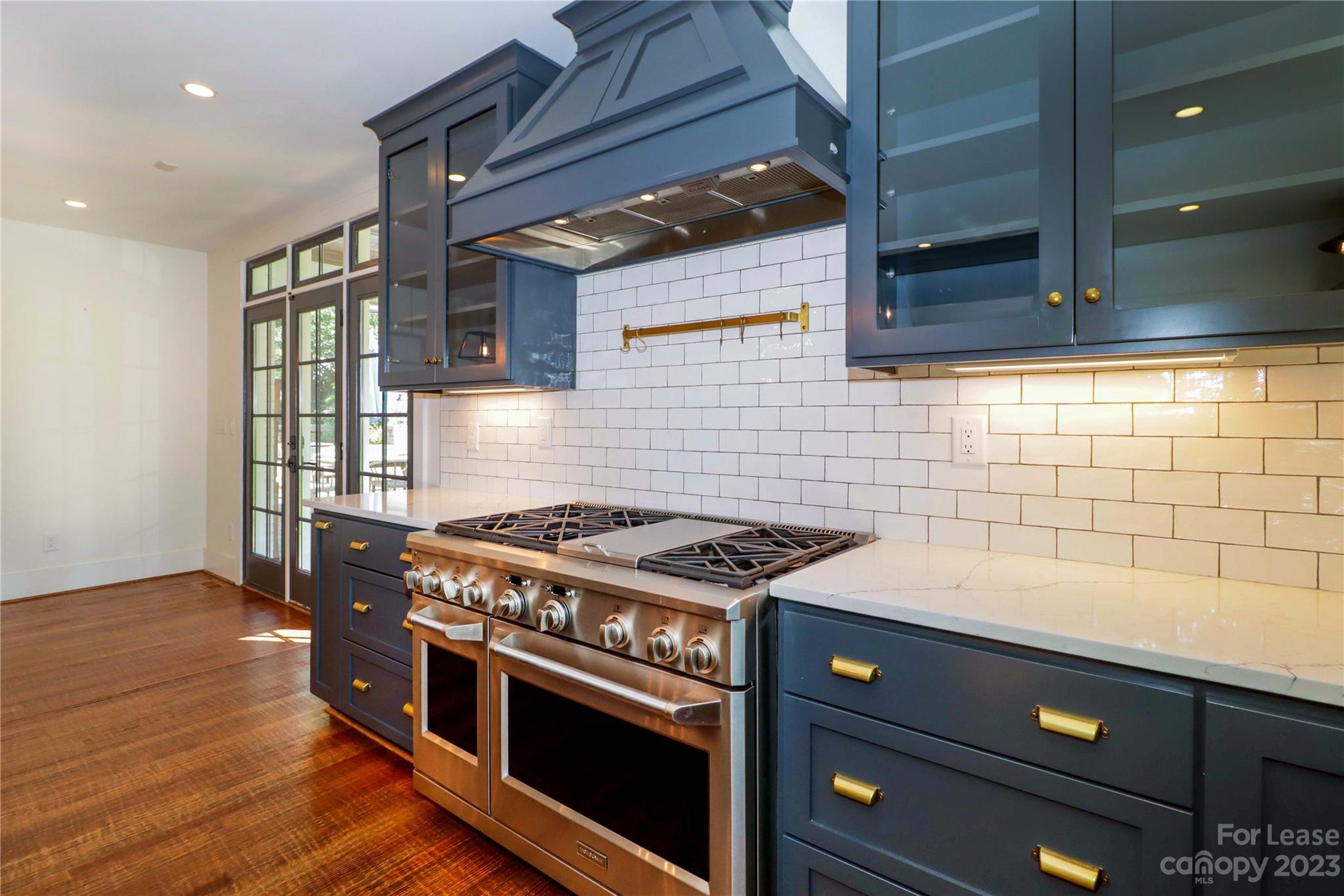 517 Lorimer Road Davidson, NC 28036 - Photo 18 of 48 a kitchen with a stove and wooden cabinets