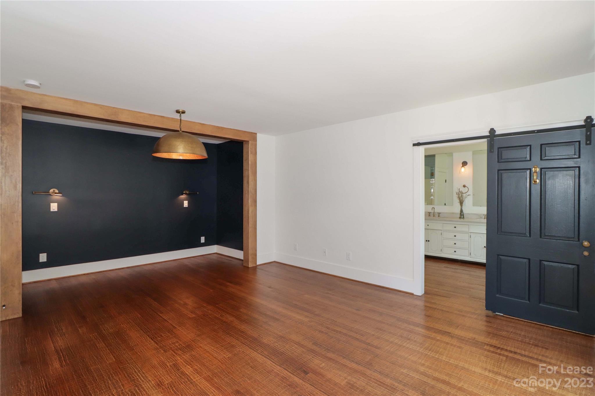 517 Lorimer Road Davidson, NC 28036 - Photo 20 of 48 a view of an empty room with wooden floor and a bathroom