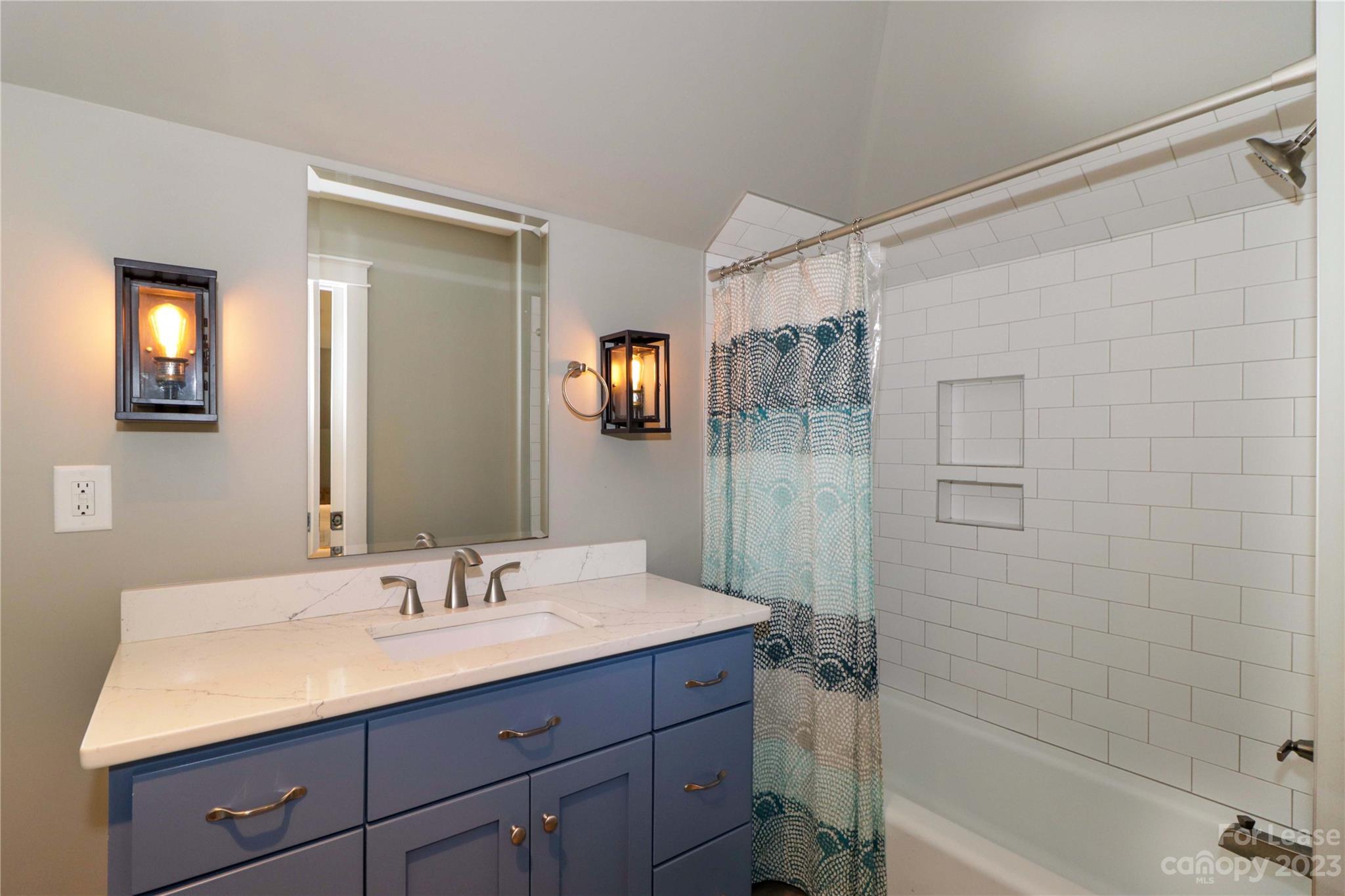 517 Lorimer Road Davidson, NC 28036 - Photo 38 of 48 a bathroom with a granite countertop sink a mirror a shower and a bathtub