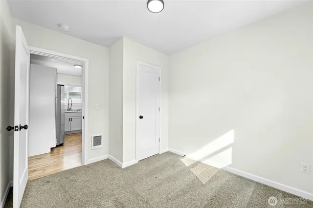 an empty room with a bathroom and mirror