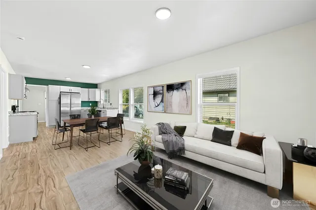 a living room with furniture wooden floor and a large window