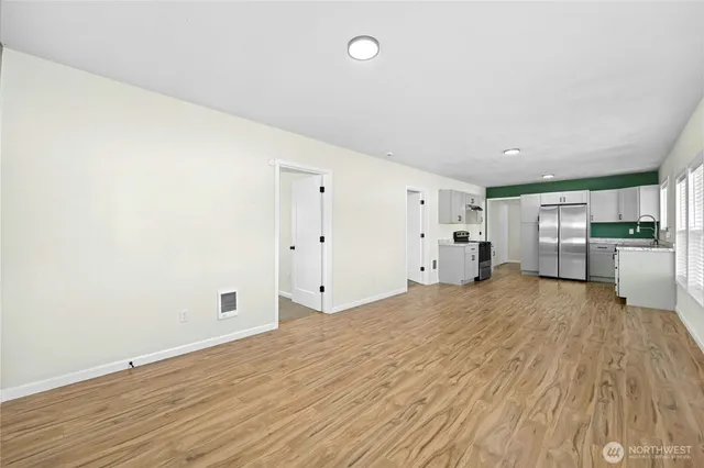 a view of empty room with wooden floor