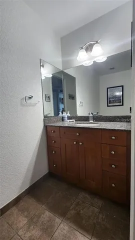 a spacious bathroom with a granite countertop sink and a mirror