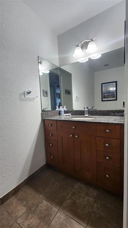 150 East Robinson Street, Unit 4A13 Orlando, FL 32801 - Photo 15 of 30 a spacious bathroom with a granite countertop sink and a mirror