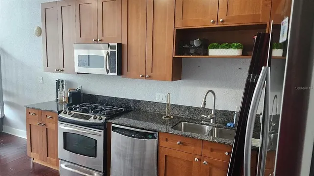 a kitchen with granite countertop a sink stove and cabinets