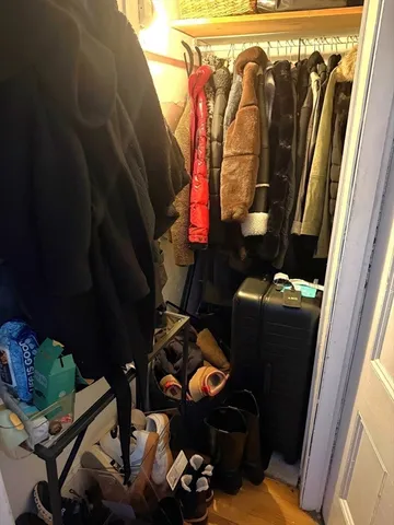 a view of walk in closet with clothes and shoes