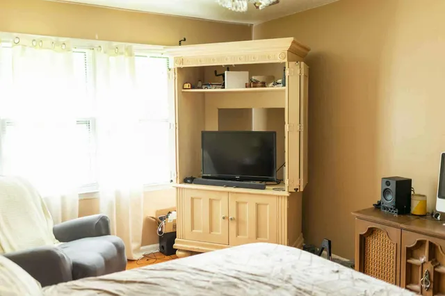 a bedroom with a bed and a flat screen tv