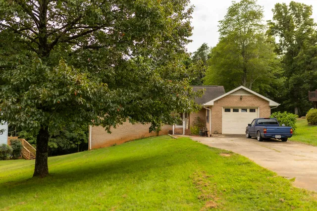 a white house with a big yard and large trees