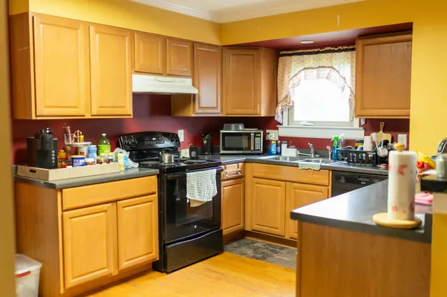 a kitchen with a sink a stove cabinets and a window