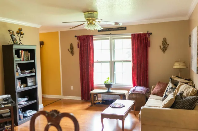 a living room with furniture a flat screen tv and a window