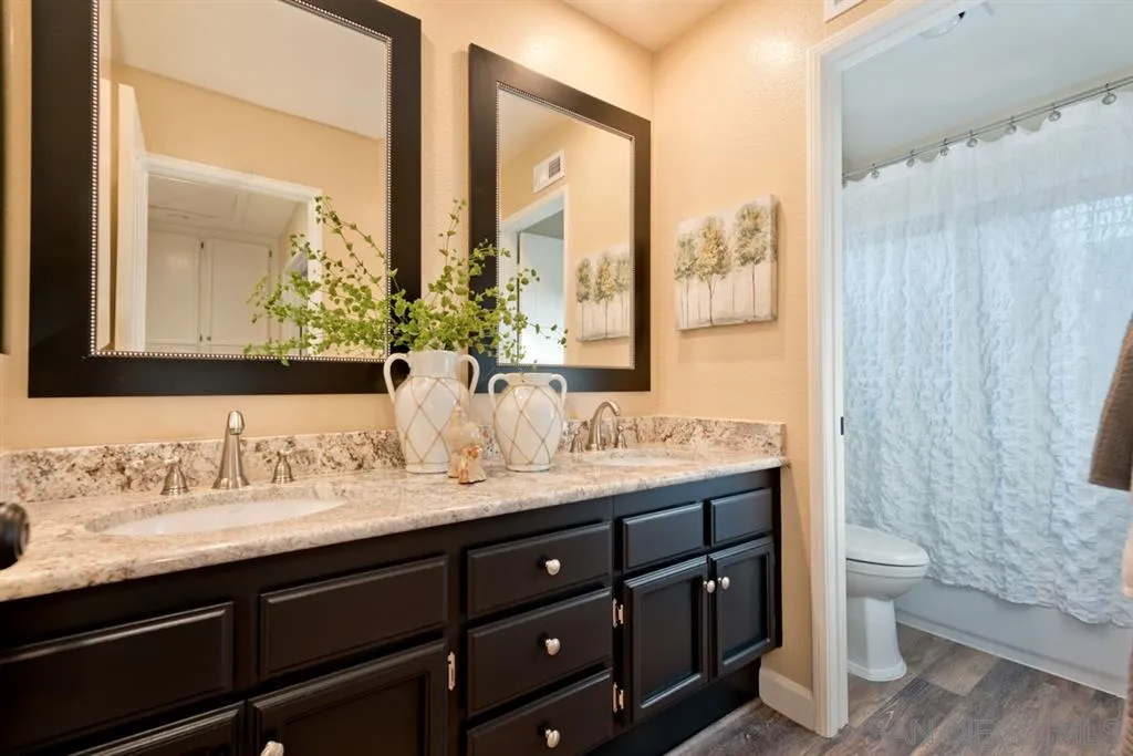 7675 Salix Place San Diego, CA 92129 - Photo 18 of 25 a bathroom with a granite countertop sink a toilet and a mirror