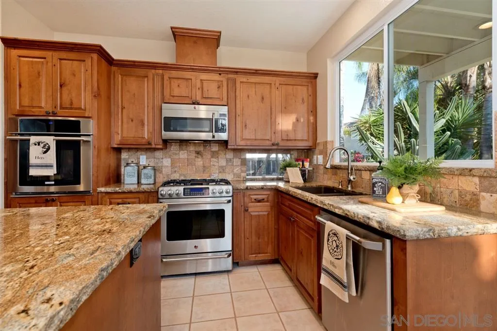 7675 Salix Place San Diego, CA 92129 - Photo 10 of 25 a kitchen with stainless steel appliances granite countertop a stove a sink and a microwave