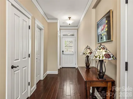 a view of a hallway with wooden floor and furniture