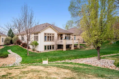 a front view of a house with a garden and trees