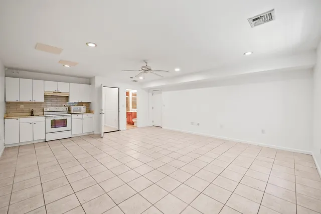 a view of a kitchen with a sink and dishwasher a refrigerator with white cabinets